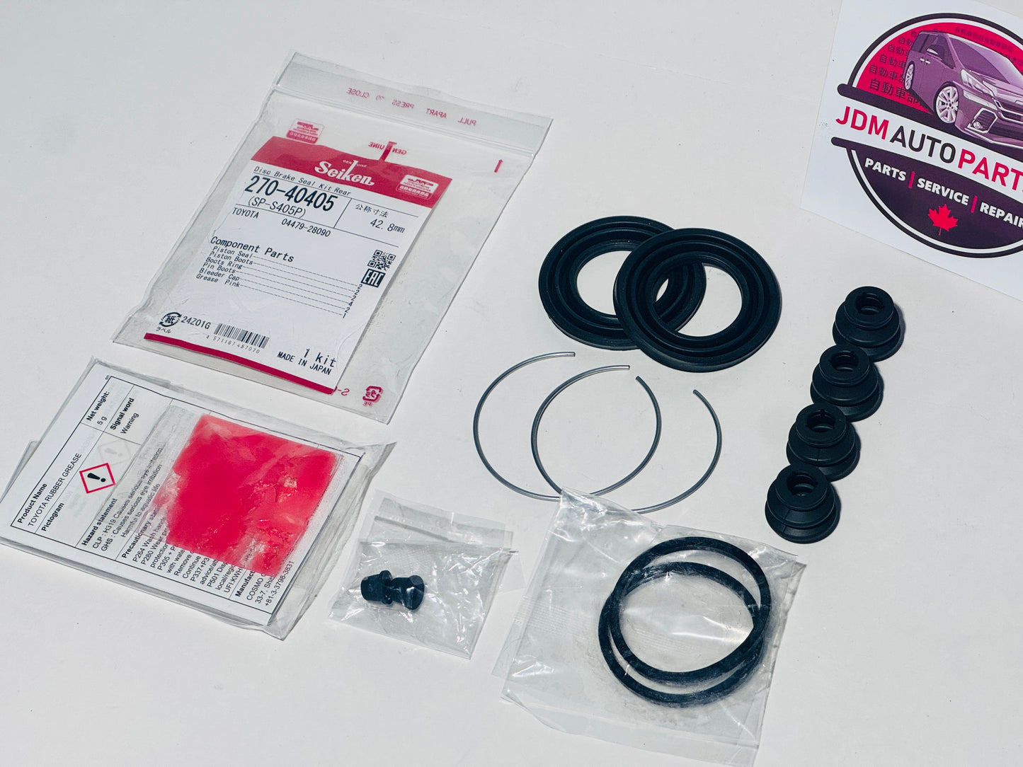 Automotive parts including seals and gaskets on a white surface with JDM Auto Parts branding. MADE FOR REAR CALIPER OF 1ST GENERATION TOYOTA ALPHARDS