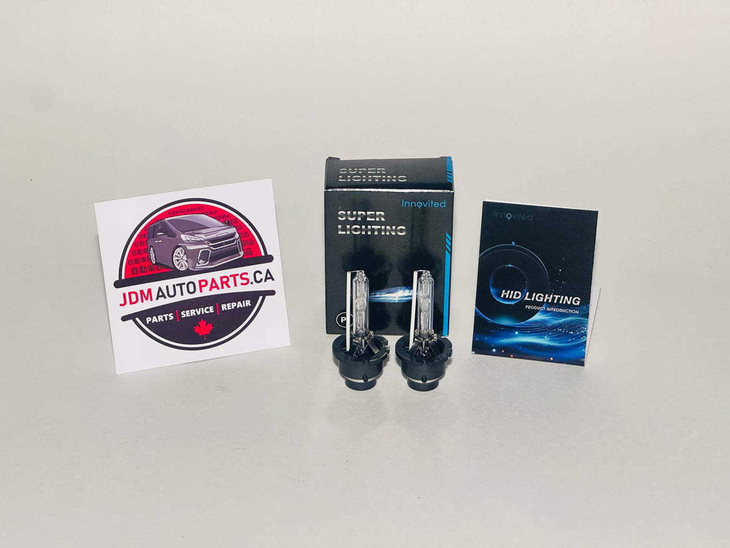 Car headlights in packaging with JDM Auto Parts CA logo on a gray background