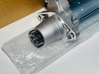 Car starter motor on a white surface with clear plastic wrap