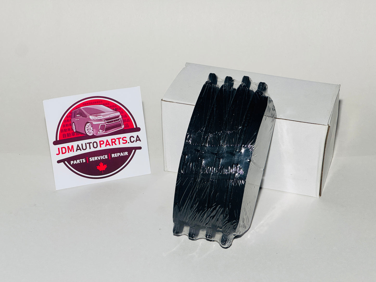 Box of black auto parts with JDM Auto Parts CA logo on a white background