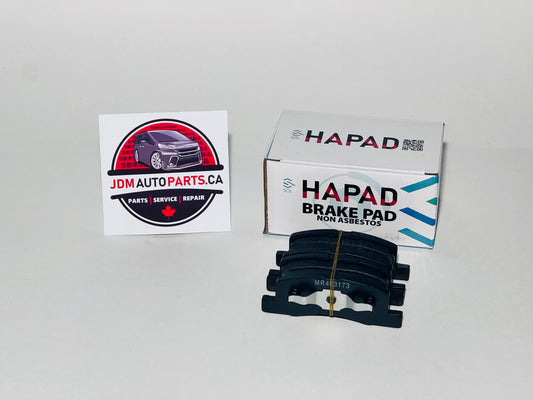 A pair of black HAPAD brake pads next to their white and blue retail box, with a JDM Auto Parts Canada sticker on a plain light gray background.