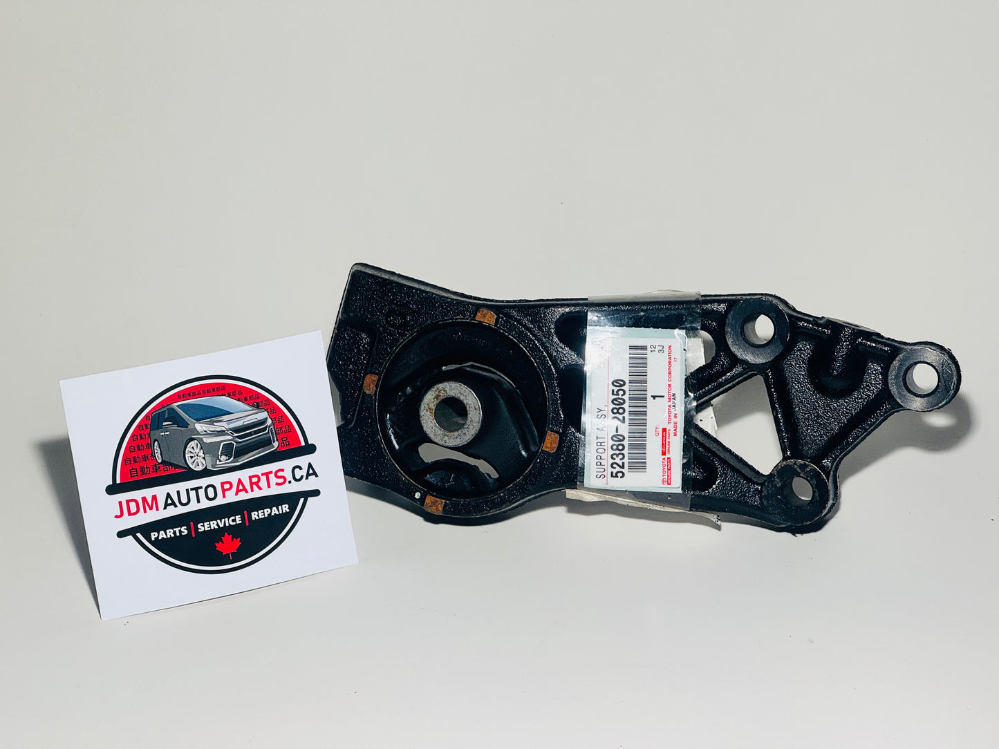 A black Toyota Estima Hybrid rear differential mount with a sticker indicating the part is for a Toyota vehicle. The part is placed against a white background.