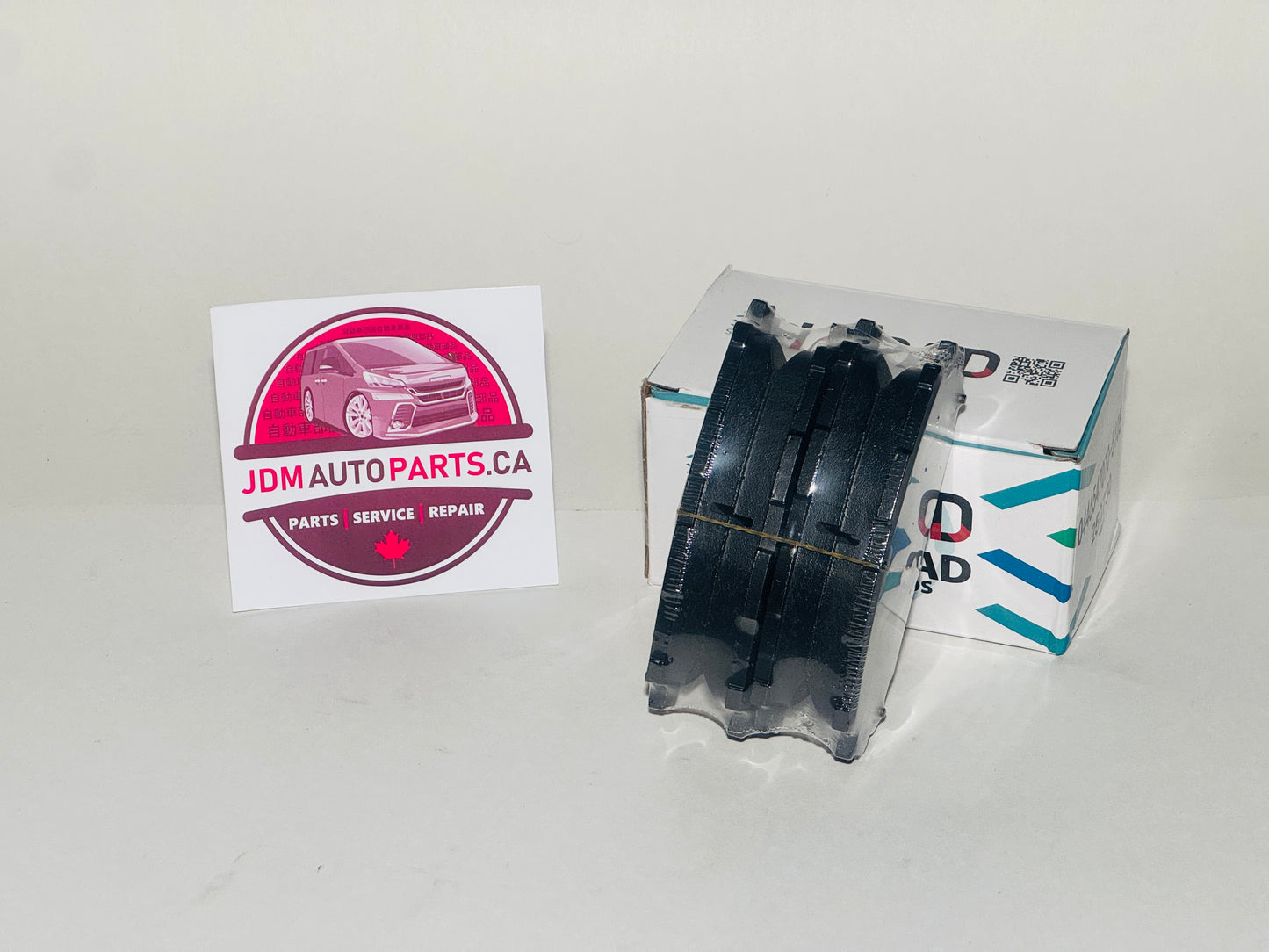 Tire and JDM Auto Parts box with a card on a white background