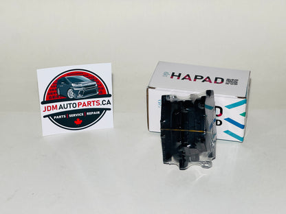 A black automotive part in clear plastic packaging stands in front of a white HAPAD box on a light gray background, with a JDM Auto Parts card on the left.