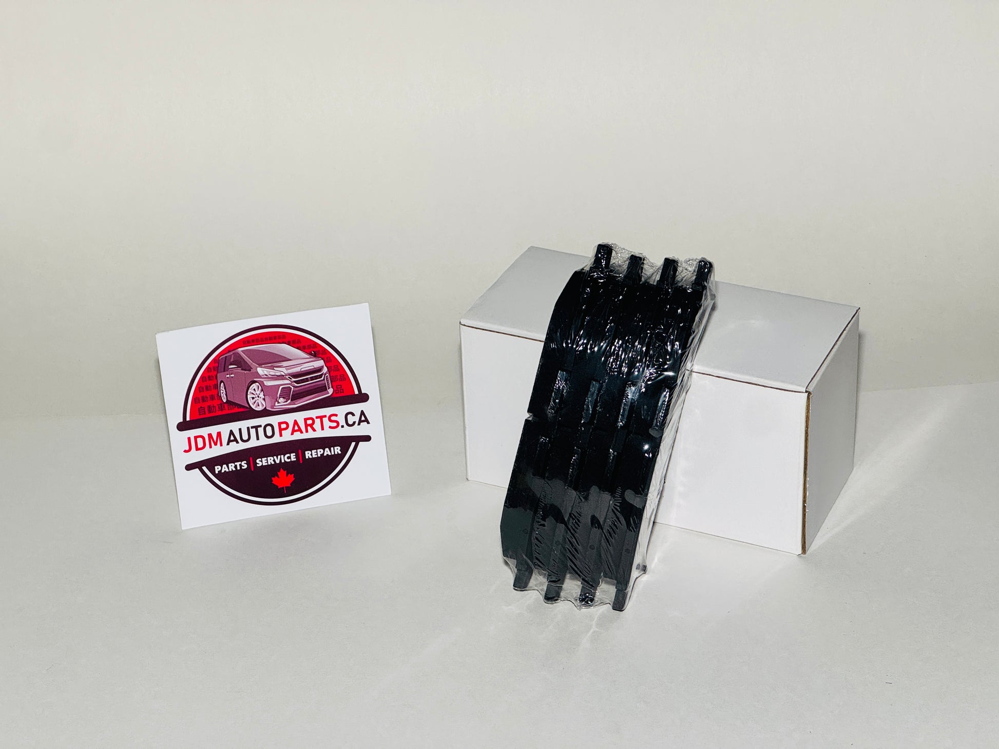 Black automotive part on a white box with JDM Auto Parts CA logo in the background