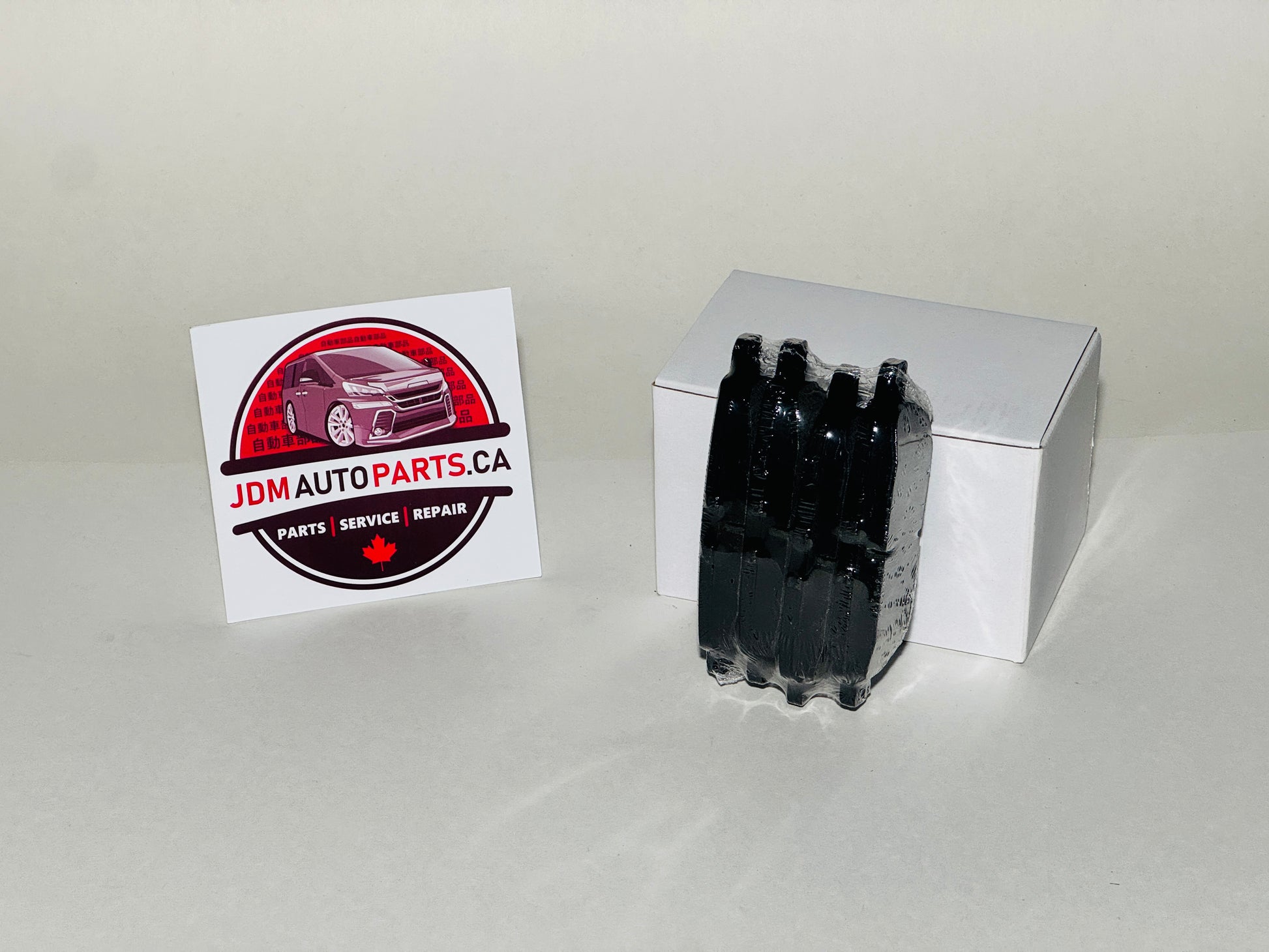 Box of brake pads with JDM Auto Parts Canada logo on a white background
