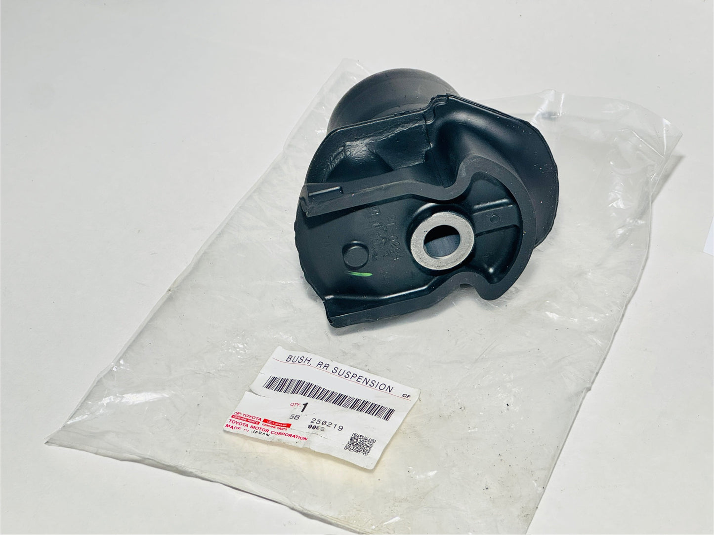 Black suspension bushing in a clear plastic bag with a label on a white background