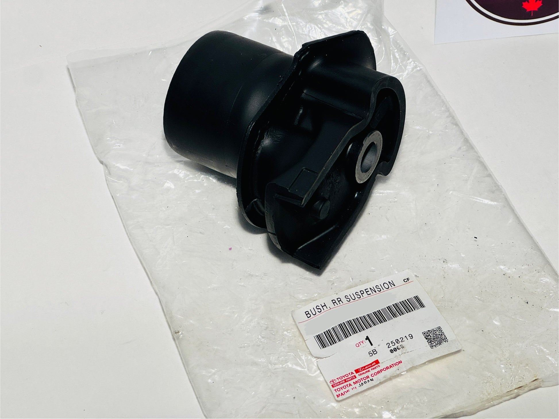 Black suspension bushing on a clear plastic bag with a label.